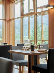 安达洛科罗纳多洛米蒂酒店的一间带桌椅和窗户的用餐室