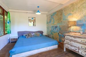 摩根湾In The Green Backpackers的一间卧室配有蓝色的床和梳妆台