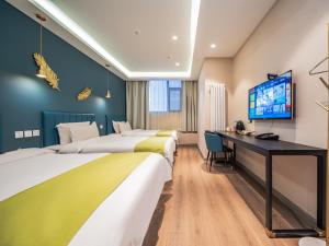 西安梧桐ins宿设计师酒店的酒店客房设有三张床和一张书桌
