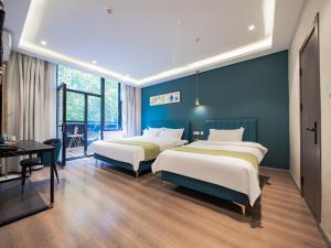 西安梧桐ins宿设计师酒店的蓝色墙壁客房的两张床