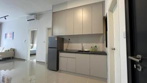 加影Cozy Studio Boulevard2 @ Kajang Town / 25-10的厨房配有白色橱柜和黑色冰箱。