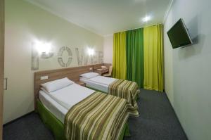 基辅Raziotel Kyiv (Boryspilska)的酒店客房设有两张床和电视。
