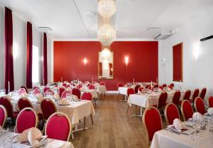 灵克宾灵克宾酒店的一间设有桌椅和红色墙壁的餐厅