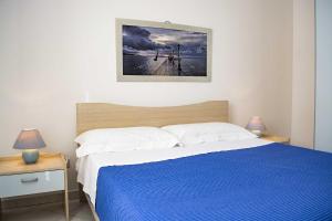 佩斯科勒海滨Appartamenti in Via Schipa Pescoluse的一间卧室配有一张带蓝色毯子的床