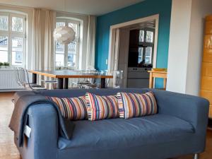 克劳斯多夫Apartment Klausdorf的客厅里一张蓝色的沙发,上面有五颜六色的枕头