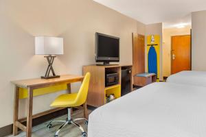 落基山黄金东部落基山戴斯酒店的酒店客房配有一张床、一张书桌和一台电视。