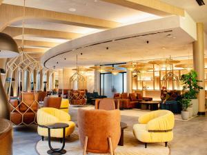 迪拜宜必思世贸中心酒店的大堂,设有黄色的椅子和桌子