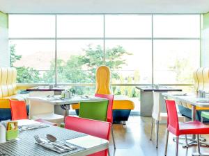 三宝垄色玛拉昂斯旁利马宜必思酒店的餐厅设有桌椅和窗户。