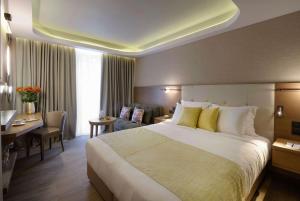 雅典雅典温德姆公寓酒店的酒店客房设有一张大床和一张书桌。