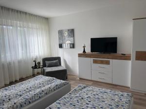 波尔塔韦斯特法利卡Monteurzimmer的一间卧室设有两张床、一台电视和一把椅子