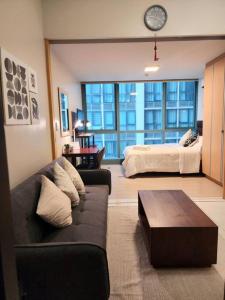 马尼拉Cozy Comfy 1BR w/ Mall access Netflix Fast Wi-fi的客厅配有沙发和1张床