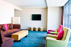 北京北京海淀雅乐轩酒店的客厅配有两张沙发和一台电视机