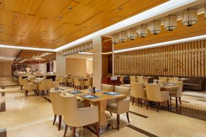 水城六盘水福朋喜来登酒店的餐厅设有木制天花板和桌椅