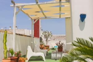 圣玛丽亚港洛斯坎塔洛斯酒店的庭院设有白色椅子和木制凉亭。