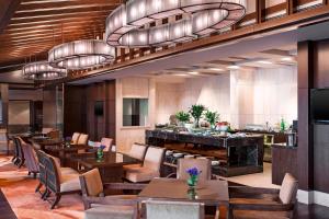 杭州杭州西溪喜来登度假大酒店的餐厅设有木桌和椅子及灯