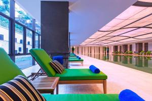 杭州杭州西溪喜来登度假大酒店的一个带绿色躺椅的游泳池和一个游泳池