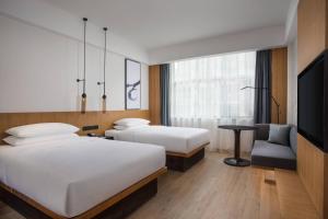 景德镇景德镇万枫酒店­­的一间酒店客房,设有两张床和电视