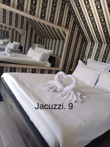 锡比乌Casa Rania的一间卧室配有两张带白色床单的床