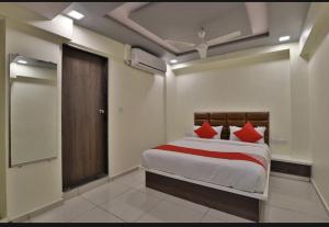 艾哈迈达巴德HOTEL SUNWAY的一间卧室配有红色枕头的床