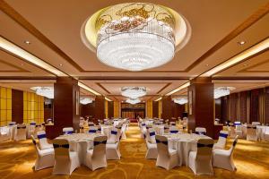 儋州儋州福朋喜来登酒店的宴会厅配有白色的桌椅和吊灯