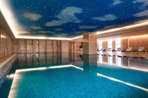 无锡无锡富力喜来登酒店的一座拥有星空天花板的建筑中的游泳池