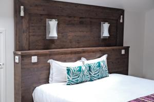 邦多勒Résidence Le Beau Rivage的一间卧室配有木制床头板和一张带枕头的床