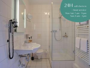 慕尼黑Classik Hotel Martinshof München Messe的一间带水槽、淋浴和卫生间的浴室