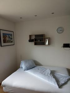 乌姆豪森Apart ban Voltas的卧室配有一张床,墙上挂着一个钟