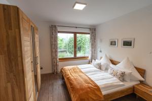 FlörsbachtalBergdorf Spessart的一间卧室设有一张大床和一个窗户。