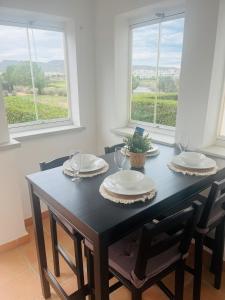 穆尔西亚La Casa Rosita, Hacienda Riquelme Golf Resort Sucina的一张带两把椅子的黑色餐桌和两个窗户
