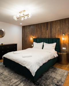 布拉索夫Rope Street eState Picturesque的一间卧室配有一张大床和绿色床头板