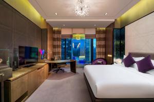 广州W Guangzhou的一间卧室配有一张床、一张书桌和一台电视