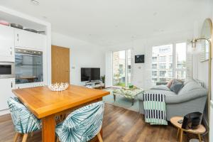 伦敦Stunning 1BR Flat in Hackney, 2 min London Fields的厨房以及带桌子和沙发的客厅。