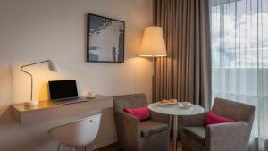 都柏林吉普森酒店的酒店的客房配有书桌和带笔记本电脑的桌子。