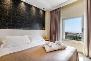 杜布罗夫尼克莱拉酒店的一间卧室设有一张大床和大窗户