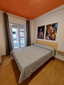 格拉纳达Arc House Granada的卧室配有一张床,墙上挂有两张照片