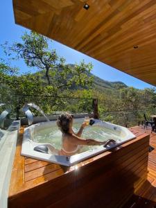 卡瓦坎特Casa Vértize, uma casa de alto padrão com Spa Hidro e vista espetacular的甲板上按摩浴缸中的女人