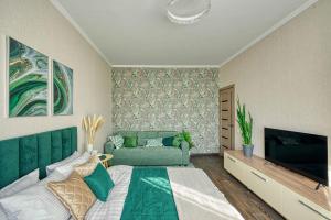 阿拉木图Green Boutique - квартира в мятных оттенках的一间卧室配有一张床和一台平面电视