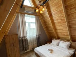 盖贝莱Qafqaz Eminent Chalet的一间卧室设有一张大床和大窗户