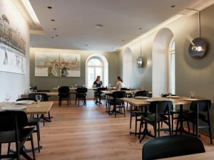 苏黎世圣约瑟夫酒店的餐厅设有木桌和椅子,客人坐在桌子旁