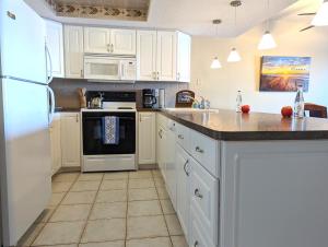 克利尔沃特Sea Club Condo #405的厨房配有白色橱柜和白色家电