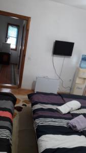 斯特鲁加Rooms Struga的一间卧室设有两张床,墙上配有电视。