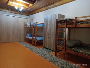 杜尚别INJIR Hostel的客房设有三张双层床,铺有木地板。