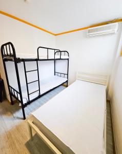 首尔Travelers A Korea Hostel的一间小房间,内设两张双层床