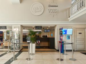马尼库尔勒翁格尔B&B HOTEL près de Disneyland Paris的商店上方带有Voss标志的购物中心