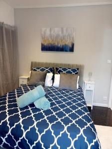 欧赖Une vue exceptionnelle sur le port de St-Goustan pour ce 2 pièces refait à neuf的卧室配有蓝色和白色的床和枕头