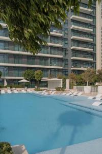 迪拜Clever Guest Beach Vista 1的一座高楼前的大型游泳池