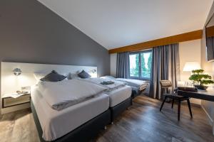 莱普海姆Hotel Leipheim Süd的酒店客房配有两张床和一张书桌