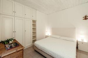蓬塔阿拉Green of Pines and Blue of Sea House的卧室配有白色的床和白色橱柜。
