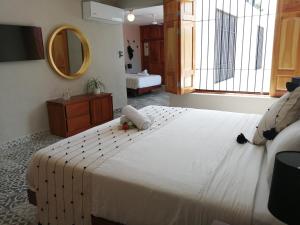 坎佩切Hotel Casa Piedad的卧室配有一张白色大床和镜子